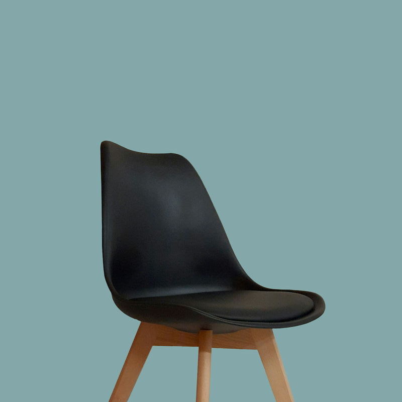 Black Scandinavian dining chair with a cushioned seat and beech legs